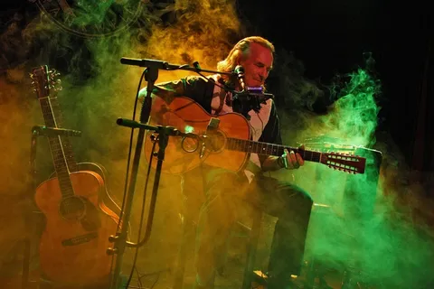 音乐家在舞台上弹吉他在烟雾中