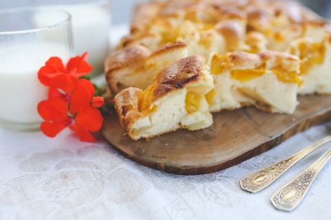 披萨,蛋挞,面包,吐司披萨,松塔饼干,自制水果派和一杯牛奶在桌子上