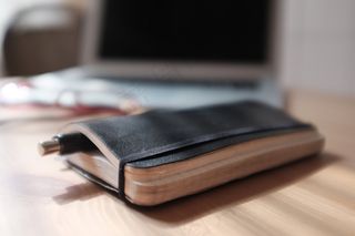 手机保护套,钱包/卡包,钱包卡包,保护套,笔记本配件,圆珠笔与笔记本电脑在背景中的笔记本