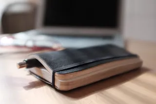 手机保护套,钱包/卡包,钱包卡包,保护套,笔记本配件,圆珠笔与笔记本电脑在背景中的笔记本