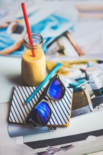 笔记本和太阳镜，一瓶酸奶在躺椅上