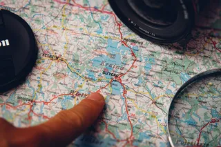 地图,耳机,设计效果图,指南针,密码锁,男子指着地图与佳能相机旁边