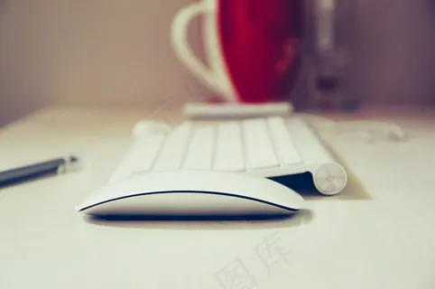 桌上的电脑键盘，鼠标和咖啡杯