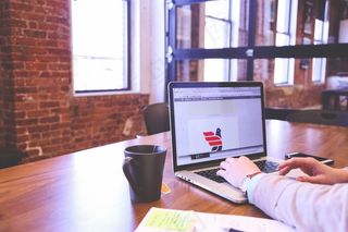 电脑,台式电脑,房间内景,办公区,与办公室的笔记本电脑上工作的人