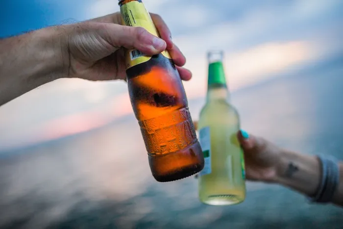 朋友在沙滩上敬酒与瓶