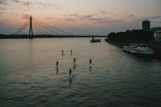 天空,飞机,桥梁,江河,街道,人们在日落时分在河上划桨