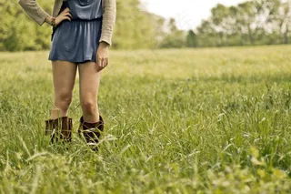 时尚的年轻女子，站在草丛中